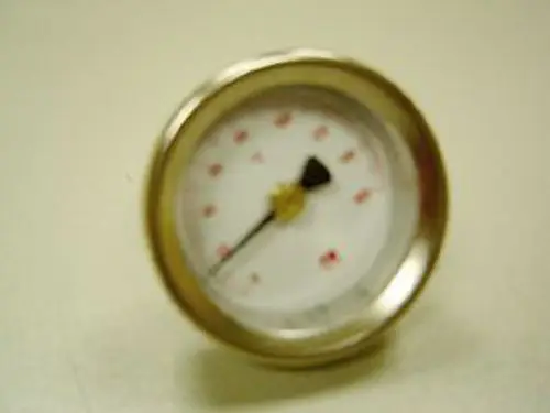 Remeha-Thermometer mit einem runden Ziffernblatt und einer Zeigeranzeige, auf einem hellen Untergrund abgebildet. Der Zeiger zeigt einen Wert auf der Skala an.